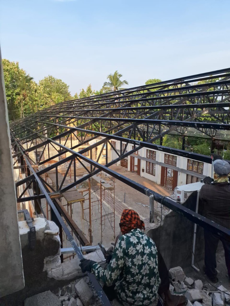 Commercial pre-engineered steel truss structure under installation by Roofopolis