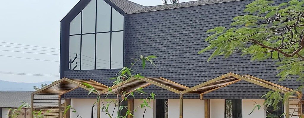 Modern A-frame building with shingle cladding by Roofopolis