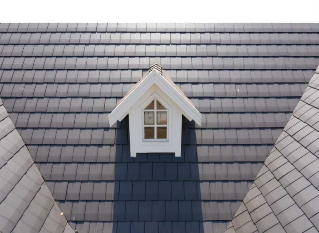Grey flat tile roof with small dormer window